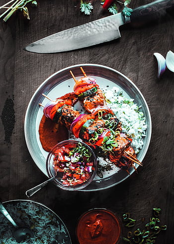 Delicious grilled skewers with rice and salsa served on a wooden table. HD phone wallpaper