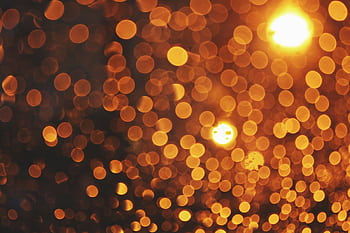 A warm golden bokeh background with abstract light circles creating a sparkling pattern. HD wallpaper