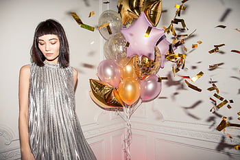 Stylish woman in silver dress celebrating birtay with balloons indoors. HD wallpaper