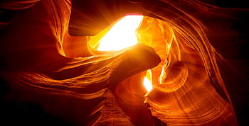 Beautiful rock formations illuminated by sunlight at Antelope Canyon, offering a vivid play of light and shadow. HD wallpaper