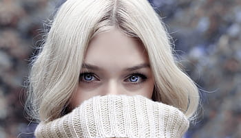 A close-up portrait of a blonde woman in winter attire, emphasizing her eyes. HD wallpaper