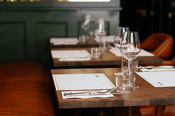Chic restaurant table setting complete with cutlery and crystal wine glasses for an upscale dining experience. HD wallpaper