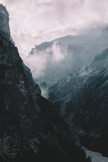 Misty and dramatic mountain landscape enveloped in clouds, showcasing nature's majestic beauty. HD phone wallpaper