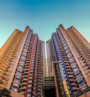 Tall, colorful skyscrapers reaching into the blue sky in Hong Kong, showcasing modern architecture. HD phone wallpaper