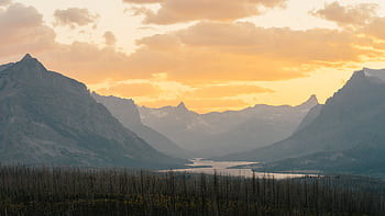 Vibrant sunrise at Glacier National Park, highlighting stunning mountain landscapes and serene river views. HD wallpaper