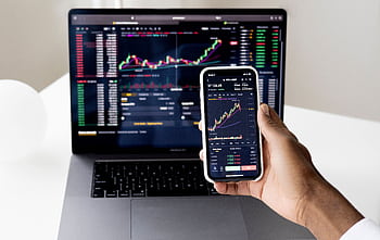 Person checking stock market graphs on laptop and smart, focusing on financial data. HD wallpaper