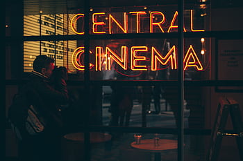 A grapher captures the vibrant neon glow of a cinema sign during the evening. HD wallpaper