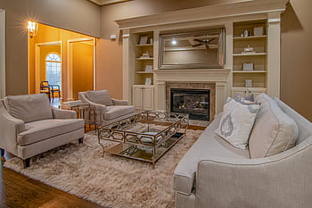 Luxurious living room featuring modern furniture and a cozy fireplace for a warm ambiance. HD wallpaper