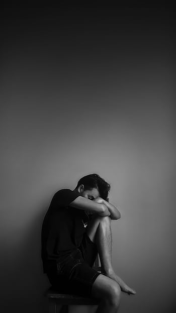 A black and white portrait of a man sitting alone, evoking emotion and contemplation. HD phone wallpaper