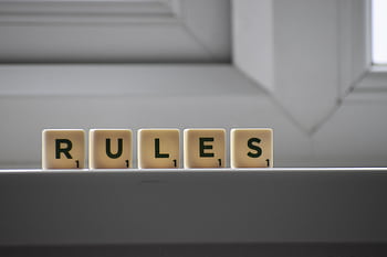 Scrabble tiles on a windowsill spell 'Rules' with a minimalist design. HD wallpaper