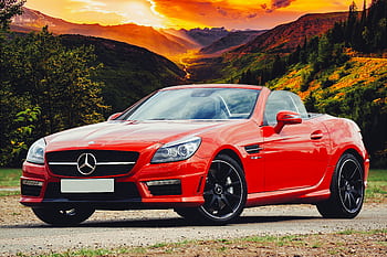Stunning red Mercedes Benz convertible parked against a breathtaking Scottish sunset backdrop. HD wallpaper