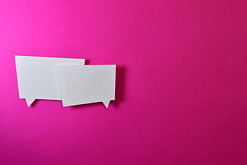 White speech bubbles on a vibrant pink background for communication or design concepts. HD wallpaper