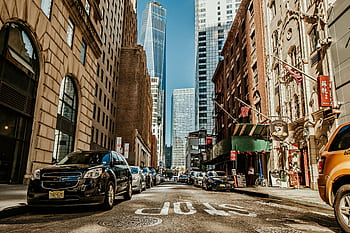 Dynamic street view of New York City with skyscrapers and urban life. HD wallpaper