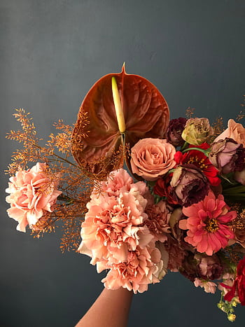 A rich and colorful flower bouquet set against a dark background, showcasing diverse floral beauty. HD phone wallpaper