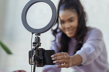 African American woman setting up smart on tripod for vlogging indoors. HD wallpaper
