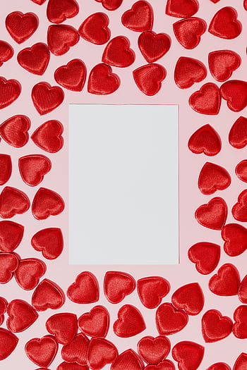 Romantic Valentine's Day frame with scattered red hearts on a pink background, perfect for creating loving messages. HD phone wallpaper