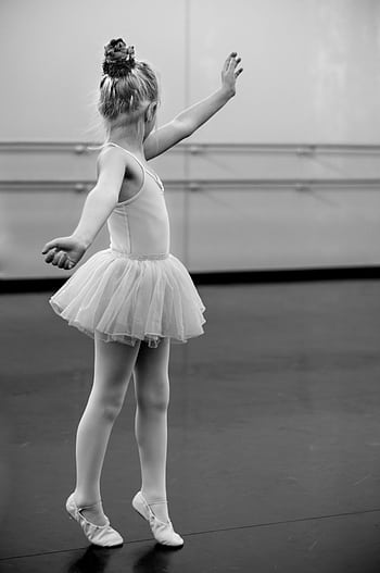 Graceful young ballerina practicing ballet moves in an elegant tutu inside a dance studio. HD phone wallpaper