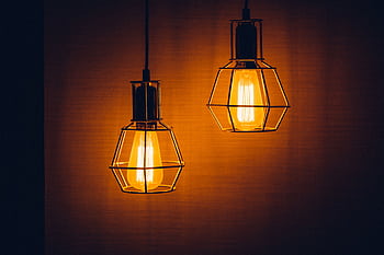 Close-up of glowing vintage pendant light bulbs creating a warm, inviting ambiance. HD wallpaper
