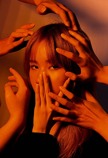 An artistic portrait of a young woman surrounded by hands, expressing emotions in moody lighting. HD phone wallpaper