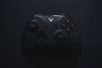 Xbox controller illuminated against a dark background, perfect for gaming themes. HD wallpaper