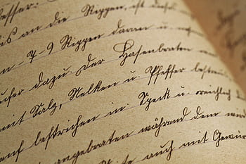 Close-up of vintage handwriting on antique aged paper with sepia tones. HD wallpaper