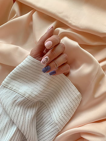 Close-up of a stylish, manicured hand with unique nail art, gracefully placed on pastel fabric. Perfect for style and beauty themes. HD phone wallpaper