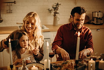 Family enjoying a cozy holiday dinner together, sharing love and joy indoors. HD wallpaper