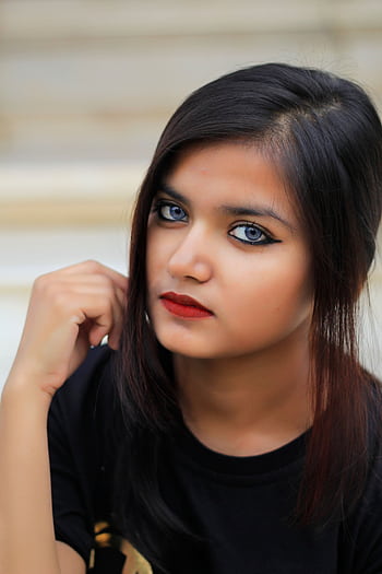 Striking portrait of a young woman with captivating eyes and red lips. Perfect for fashion and makeup themes. HD phone wallpaper