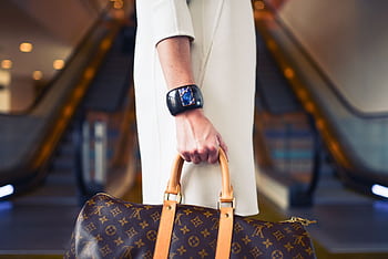 Chic woman with luxury handbag and bracelet in modern shopping environment. HD wallpaper