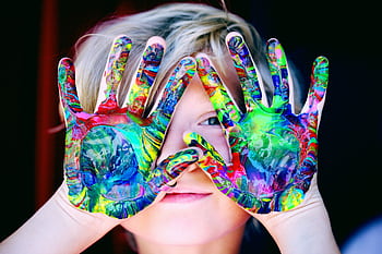 Vibrant close-up of a child's hands covered in colorful paint, expressing creativity and fun. HD wallpaper