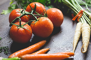 Close-up of fresh tomatoes and carrots with water droplets on a wooden surface. HD wallpaper