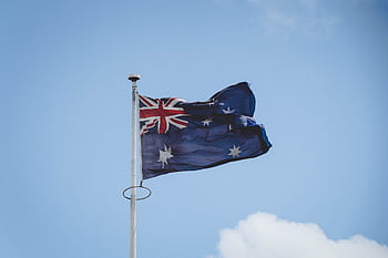 Australian national flag waving on a flagpole against a clear blue sky in Perth. HD wallpaper