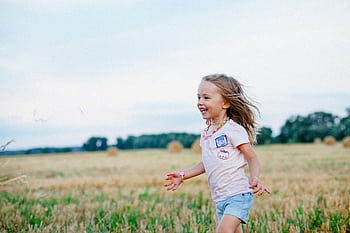 A joyful child running ly through a summer field, embracing the spirit of fun and dom. HD wallpaper