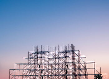 A silhouetted structure against a colorful sunset, showcasing industrial scaffolding in Sochi, Russia. HD wallpaper