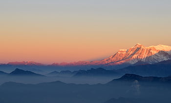 A breathtaking view of the Himalayan mountains at sunrise, showcasing the majestic peaks and serene atmosphere. HD wallpaper
