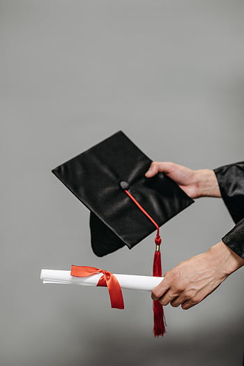A close-up of a graduation cap and rolled diploma symbolizing achievement and success. HD phone wallpaper