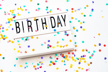 A vibrant birtay celebration background with colorful confetti and a birtay sign. HD wallpaper