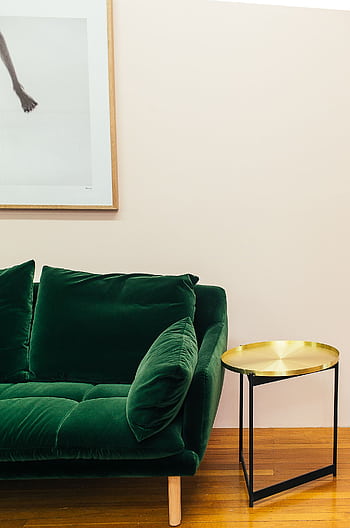 Elegant living room setup featuring a plush green sofa and a chic gold side table. HD phone wallpaper