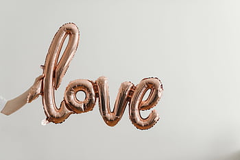 Elegant rose gold balloon spelling 'love' on a soft background, perfect for Valentine's Day themes. HD wallpaper
