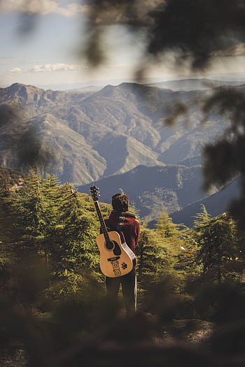 A guitarist stands in awe of the mountain scenery in Algeria, capturing the essence of nature and music. HD phone wallpaper