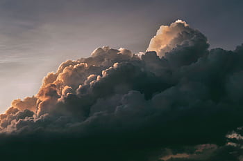 A beautiful and dramatic cloudscape with warm sunlight peeking through at twilight, creating a serene sky. HD wallpaper