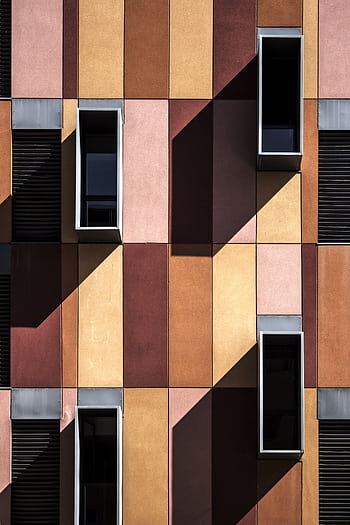 Colorful modern facade with geometric design and shadows highlighting windows. HD phone wallpaper