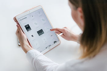 A woman interacts with a tablet to create digital art. Ideal for technology and creativity concepts. HD wallpaper