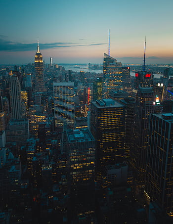 A breathtaking view of New York City's skyline at dusk, showcasing iconic skyscrapers and city lights. HD phone wallpaper