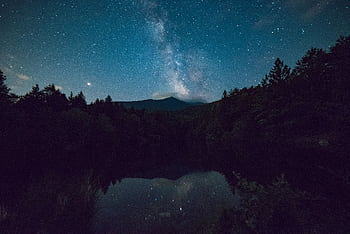 A que night sky with Milky Way over a serene mountain and forest landscape. HD wallpaper