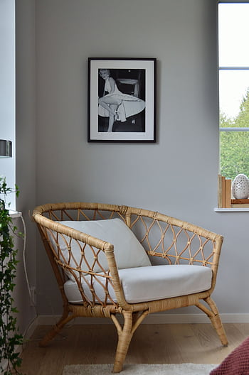 A stylish wicker chair in a Scandinavian-designed room with a framed on the wall. HD phone wallpaper