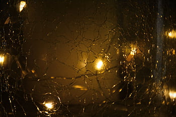 Cracked glass with a warm glow and bokeh effect, creating an abstract design. HD wallpaper