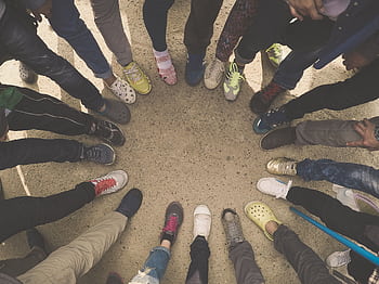 A group of people forming a circle with their sneakers, symbolizing diversity and unity. HD wallpaper