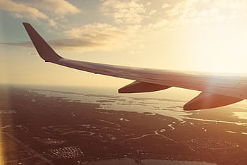 Stunning aerial view of a plane wing flying over Fort Myers, Florida during a warm sunset. HD wallpaper