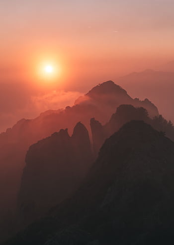 Dramatic sunset over silhouetted mountain peaks in Piani Resinelli, Italy, creating a serene landscape. HD phone wallpaper